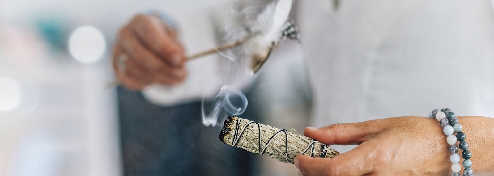 Inciensos 100% Naturales 1 Woman’s hand holding bundle of dried sage herb, performing smudging ritual, cleansing negative energy and purifying living space with smoke